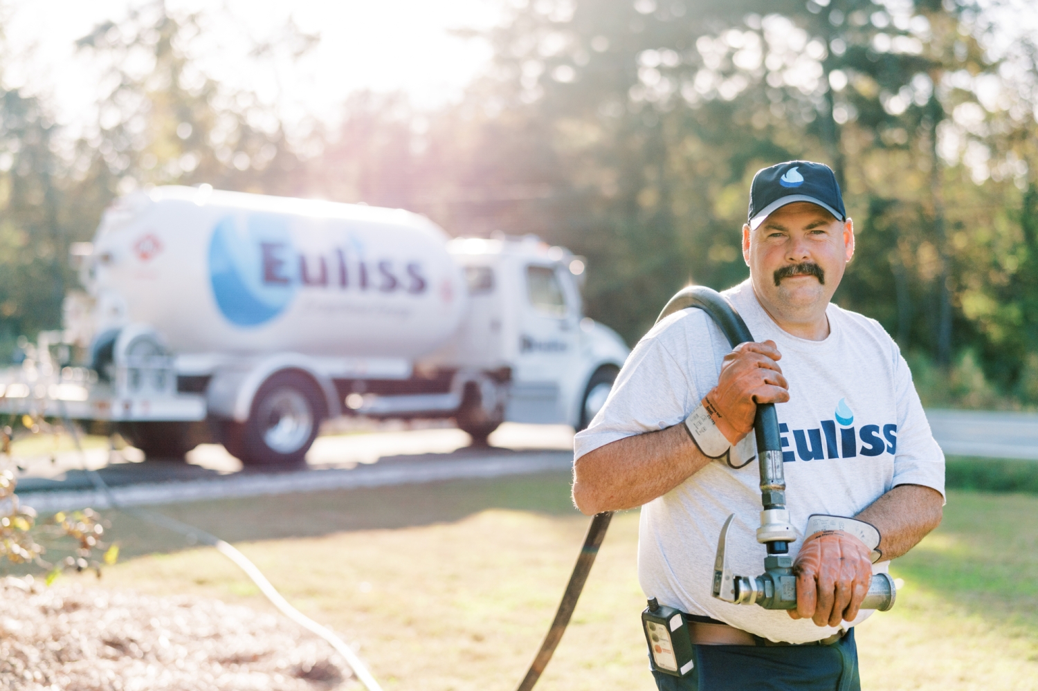Professional photography of a technician from Euliss Propane pulling a hose from his propane truck